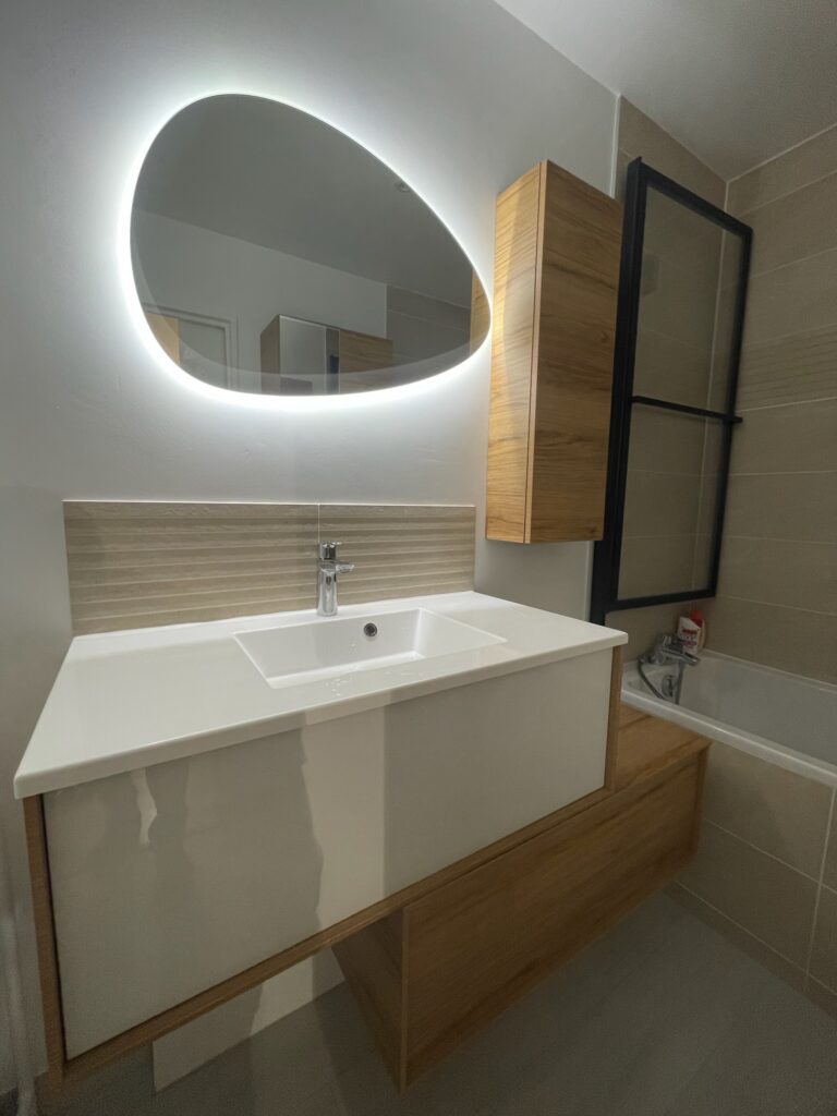 Salle de bain rénovée avec miroir LED et meuble vasque bois