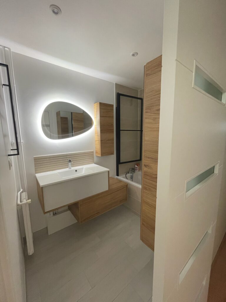 Salle de bain moderne avec miroir rétroéclairé et colonne en bois