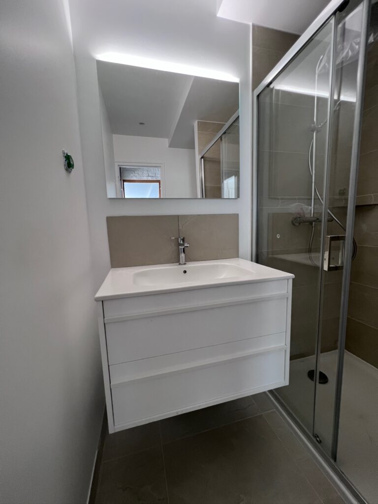 Salle de bain rénovée avec douche et meuble suspendu